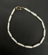 Collar tipo gargantilla compuesto por perlas de río naturales en formato tubular, con acabado orgánico y brillo suave.