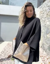 Saco tejido de punto en color negro, con corte holgado y mangas tres cuartos. Presenta bolsillos frontales amplios confeccionados en cuero metalizado color plateado y cierre frontal con botones.