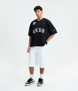 Remera negra de corte boxy y estilo deportivo, confeccionada en tejido de malla de poliéster. Presenta cuello en V, mangas corta, estampado numérico "33" en el pecho derecho y la inscripción "CLUB" en tipografía gótica en el centro.