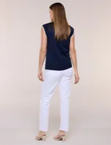 Blusa de punto fino azul marino sin mangas, con escote redondo y sisas decoradas con ribete festoneado blanco.