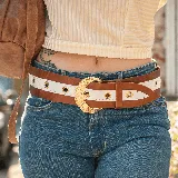 Cinto ancho de cuero color marrón con franja central blanca y hebilla dorada en forma de media luna.