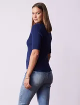 Buzo azul de tejido acanalado, con cuello solapa y escote en V en tejido calado.