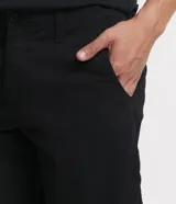 Bermuda masculina de corte slim, confeccionada en tejido de sarga de algodón. Presenta un diseño de sastrería con cierre de botón y cremallera, bolsillos laterales y traseros, y un acabado liso sin estampados.