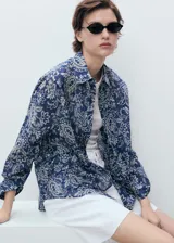 Camisa azul con estampado de cachemir en blanco, de corte recto y manga larga.