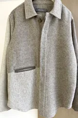 Camisa estilo leñadora con diseño patchwork en tonos marrones y beige. Presenta coderas, cartera americana y bolsillo ojal en el delantero. Confeccionada en Uruguay con tela 100% lana fina sin teñir.