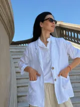 Blazer blanco de lino con solapas y bolsillos frontales.