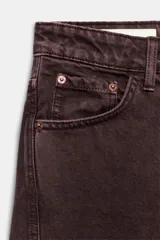 Jeans de tiro medio color marrón con diseño de volumen crop, silueta holgada en las piernas y cinco bolsillos tradicionales. Cierre frontal con cremallera y botón metálico.