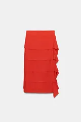 Falda midi de tiro medio en color rojo, confeccionada en tejido con viscosa. Presenta un diseño de capas horizontales con volantes laterales y cierre de cremallera oculta en la costura.