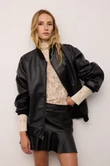 Campera bomber de cuero vacuno en color bordó, con diseño oversized y corte bombé. Presenta cierre frontal, bolsillos laterales y terminaciones de puños, cuello y pretina en tejido de algodón acanalado a tono.