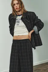 Pantalón de tiro alto con diseño de cuadros, pernera recta y cintura con trabillas. Cuenta con bolsillos laterales, bolsillos de vivo en la parte posterior y cierre frontal con cremallera, botón oculto y gancho metálico.