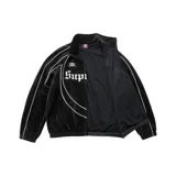 Campera deportiva de terciopelo negro Supreme x Umbro, con cierre frontal, cuello alto y ribetes blancos. Cuenta con bolsillos laterales, el logotipo de Umbro, el escudo del Club Nacional de Football y la inscripción 'Supreme' en tipografía gótica en el frente.