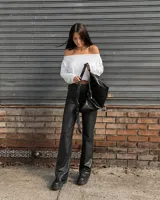 Pantalón negro de cuerina, tiro medio y corte recto.