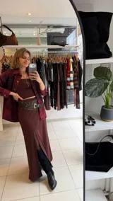 Falda midi color marrón, de tiro alto y confeccionada en lycra elastizada, con tajo frontal pronunciado.