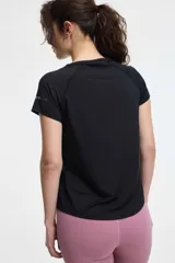 Remera deportiva de manga corta con cuello redondo y costuras tipo raglán. Confeccionada en tejido técnico elástico, presenta un diseño liso y entallado, ideal para actividades físicas.