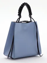 Cartera celeste de cuero con asa corta trenzada color negro y tiras colgantes decorativas.