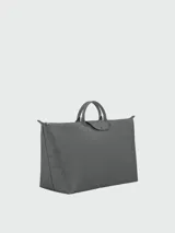 Bolso de viaje de gran tamaño Longchamp modelo Le Pliage One, confeccionado en nylon resistente con detalles en cuero. Presenta un diseño minimalista con cierre superior, doble asa de mano y solapa frontal con botón a presión.
