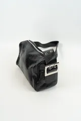 Cartera de hombro color negro con acabado brillante, diseño rectangular y correa ajustable con detalles metálicos.