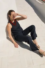 Pantalón de lino negro con tiro medio, corte recto y aberturas laterales en el dobladillo inferior.