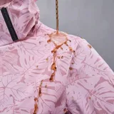 Campera cortaviento impermeable de la marca Uniteduy, color negro con estampado sutil de hojas. Cuenta con capucha, cierre frontal, tres bolsillos externos y uno interno. Es una prenda ultra liviana y transpirable, ideal para actividades al aire libre.