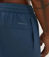 Bermuda deportiva masculina con cintura elástica y cordón de ajuste. Presenta bolsillos laterales y aberturas en el bajo para mayor movilidad.