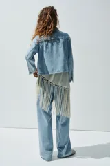 Campera corta en denim de algodón con cuello, cierre de botones y canesú en la espalda. Modelo ajustado con bolsillos parche adelante y puños abotonados.