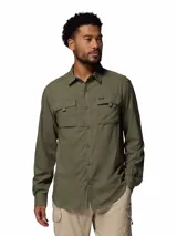 Camisa de manga larga Columbia, color verde militar, con cuello clásico, cierre frontal de botones y dos bolsillos frontales con solapa. Presenta tecnología de protección solar y tejido transpirable de secado rápido.