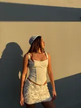 Corset de encaje color crema con escote recto, tirantes anchos y diseño estructurado con costuras verticales.