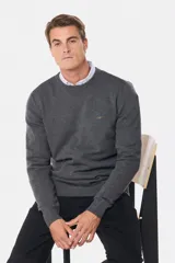 Buzo tejido de lana con escote redondo a la base y mangas largas. Presenta puños y ruedo acanalados, con un pequeño logo bordado en el pecho.