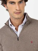 Sweater de punto color verde militar con cuello alto y medio cierre frontal de cremallera, manga larga y detalles acanalados en los puños y el dobladillo.