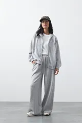 Campera con capucha y cierre frontal, de silueta relajada, hombros caídos y bolsillos laterales. Presenta terminaciones elastizadas en puños y ruedo, con líneas de recorte frontales y cierre metálico con tirador circular.