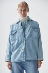 Sobrecamisa celeste de denim con bolsillos frontales con solapa y cierre abotonado.
