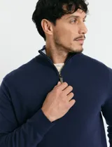 Remera de punto con medio cierre frontal, manga larga, cuello y puños en tejido canalé. Presenta un diseño con cierre metálico y detalle de puller en tono oliva.