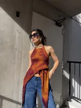 Top halter con diseño asimétrico y efecto tie-dye en tonos naranja y marrón, con paneles largos colgantes en el frente.