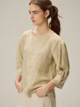 Blusa de algodón en color beige, con escote redondo y mangas de tres cuartos abullonadas.