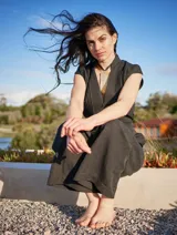 Mono color arena de lino, con cuello mao, cierre frontal con cremallera, mangas cortas y cinturón de lazo.