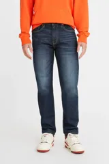 Jean de corte regular taper, con tiro medio y diseño de cinco bolsillos. Presenta un lavado azul oscuro con efecto desgastado y costuras en contraste.