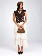Blusa sin mangas de viscosa color negro con estampado de lunares blancos, cuello redondo y cintura fruncida con elástico.