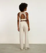 Pantalón deportivo de corte recto confeccionado en microfibra color beige. Presenta cintura elástica con lazo ajustable y bolsillos laterales.
