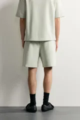 Bermuda estilo jogger de ajuste relajado, confeccionada en tejido interlock de algodón. Cuenta con cintura elástica ajustable con cordón, bolsillos frontales de vivo y diseño liso.
