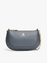 Cartera tipo baguette de Tommy Hilfiger con acabado liso, cierre de cremallera y correa de cadena metálica dorada. Presenta el monograma TH en la parte frontal.