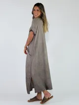 Vestido largo azul de corte recto, con escote en V, mangas cortas con flecos y bolsillos laterales.