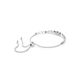 Pulsera plateada con cristales blancos redondos engarzados en bisel. Tiene un cierre deslizante que permite ajustarla a la muñeca.