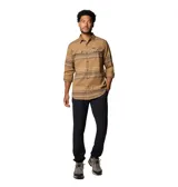 Camisa de manga larga Columbia, confeccionada en franela de algodón con un toque de elastano para mayor comodidad. Presenta un diseño de rayas horizontales en tonos tierra, cuello clásico, cierre frontal con botones y dos bolsillos en el pecho con solapa y botón.