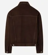 Campera trucker marrón, de corte overboxy y manga larga, confeccionada en sarga de algodón. Tiene cuello inglés, cierre abotonado, bolsillos con solapa y pespunte contrastante.