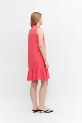 Vestido corto fucsia de lino, sin mangas, con cuello mao con volados y volado en el ruedo.