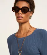 Suéter de punto acanalado color beige, con cuello redondo y mangas largas. Confeccionado en tejido tricot con textura suave y ajuste al cuerpo.