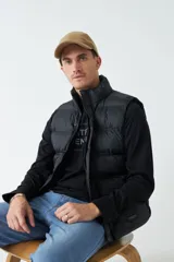 Chaleco negro de nylon con cierre frontal y bolsillos laterales.