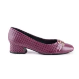 Zapato de cuero color borgoña con textura tejida, de punta redondeada y taco bajo cuadrado. Presenta un aplique dorado en la parte delantera con detalle charolado.