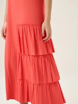 Vestido midi de morley color negro, con escote en V, mangas cortas y diseño con volados asimétricos en el lateral inferior.