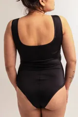 Body negro musculosa escote cuadrado, confeccionado en lycra con detalle de microtul y brillos negros. Breteles anchos y broches en entrepierna con fundillo en algodón 100%.